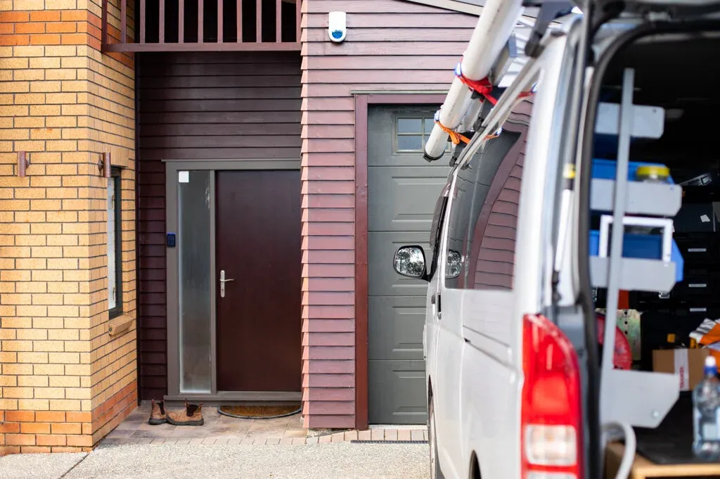 Vital Energy electrician's van parked outside an Auckland townhouse garage ready for an EV charger installation