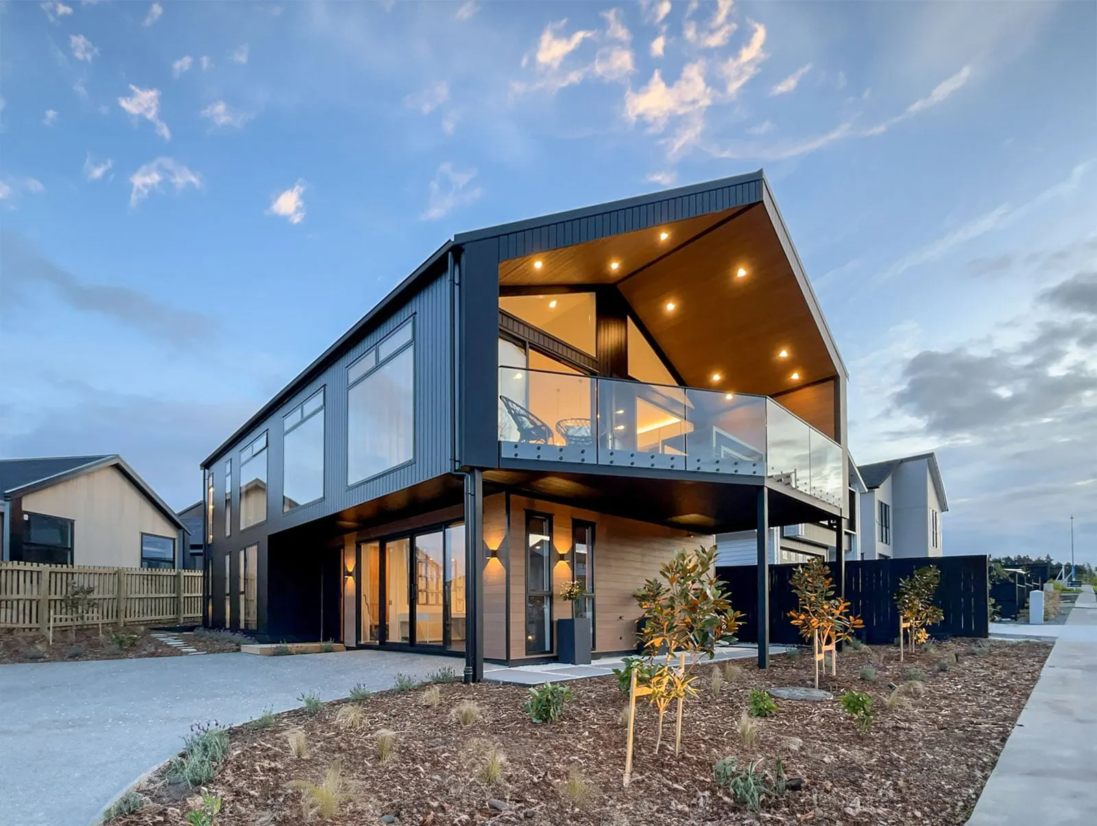 Two-storey new build home at dusk with exterior and interior lighting on
