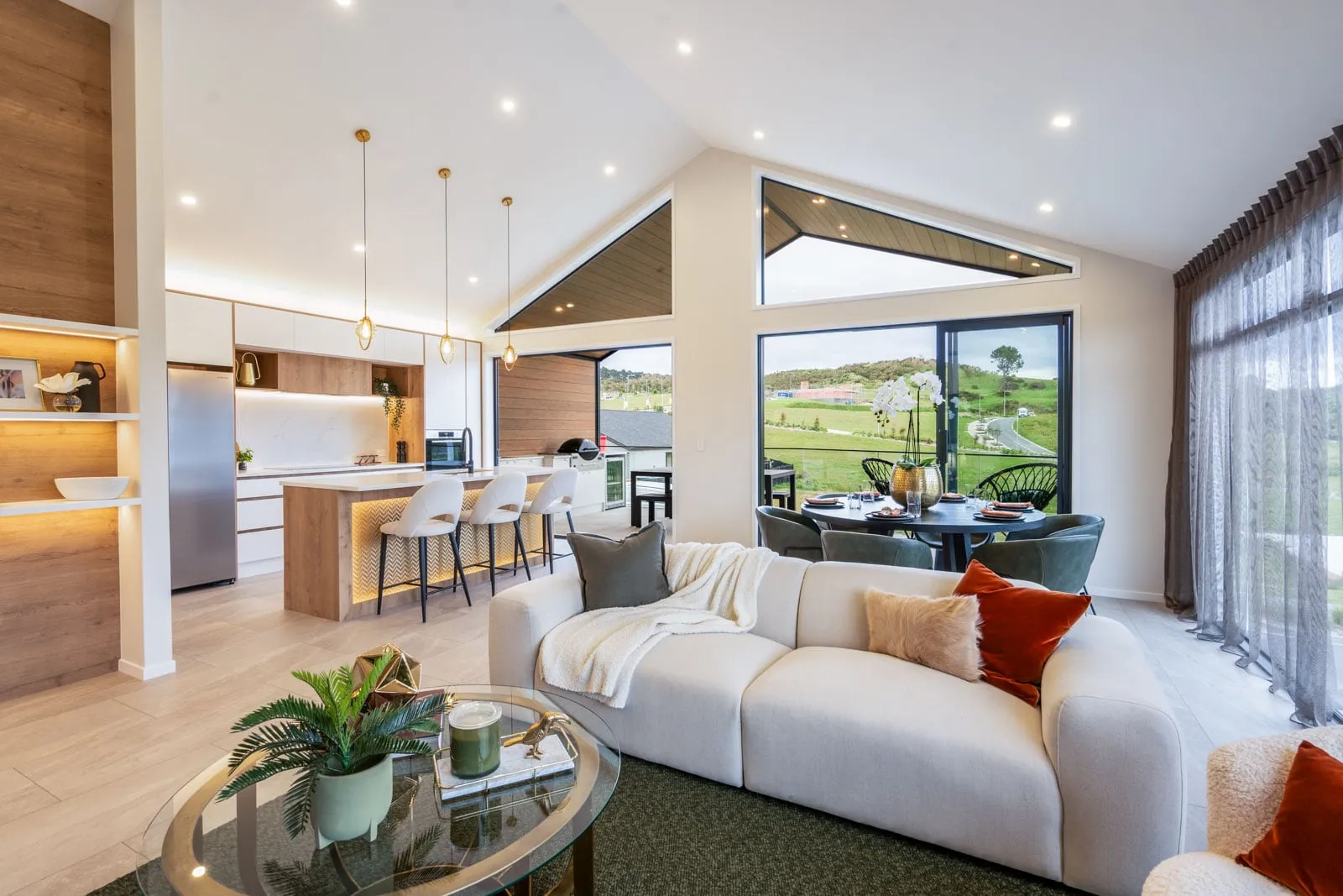 Open-plan living and kitchen in an Auckland new build with layered smart lighting