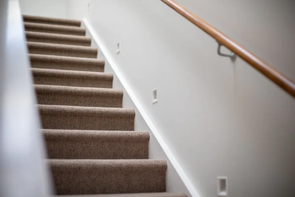 Warm, well-lit stairwell in an Auckland home after electrical work by Vital Energy